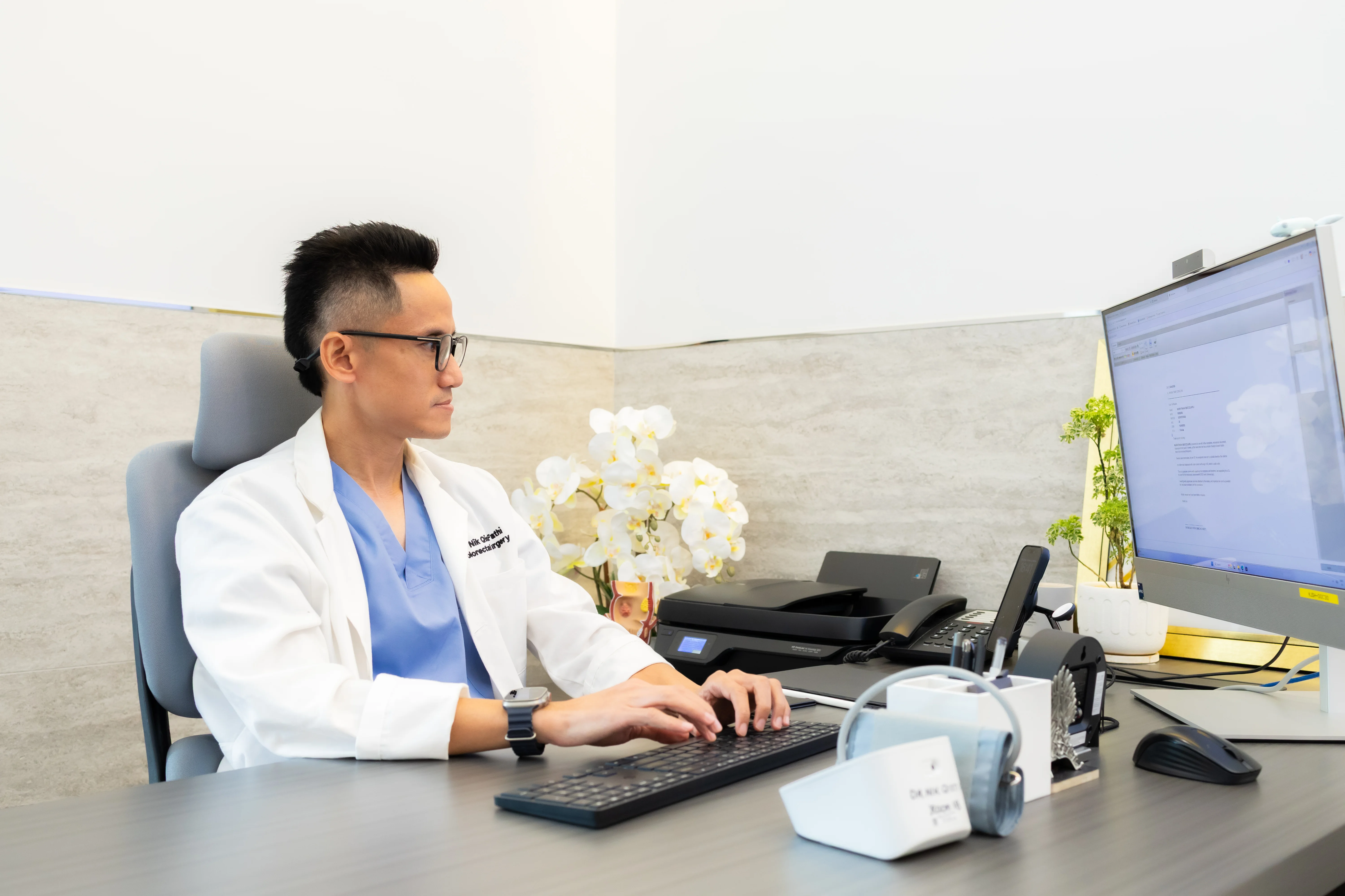 Dr. Qisti reviewing patient notes at his clinic